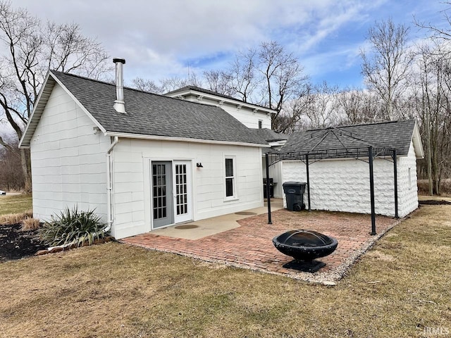 back of house with a yard, a patio, and an outdoor fire pit