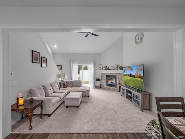 living room featuring carpet flooring, lofted ceiling, and a stone fireplace