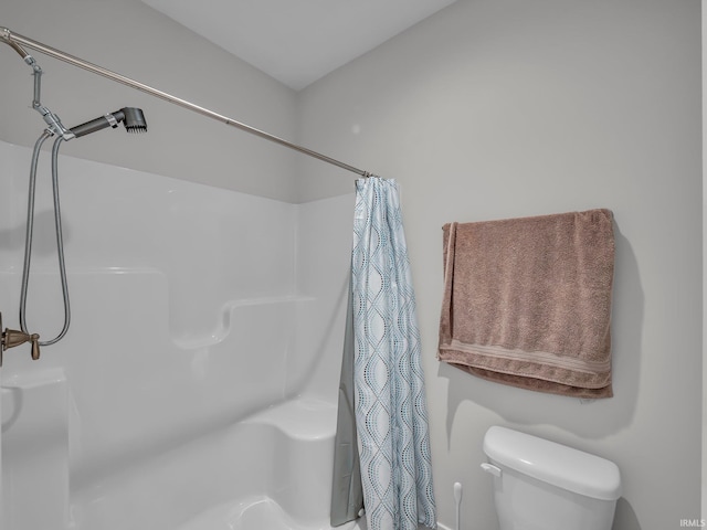 bathroom with a shower with curtain and toilet