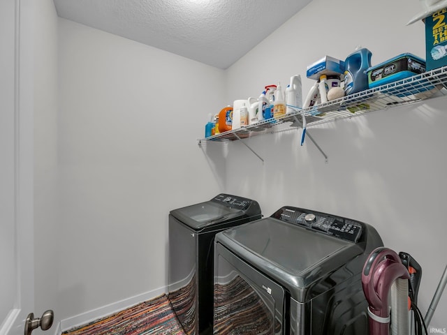 clothes washing area featuring washing machine and dryer and a textured ceiling