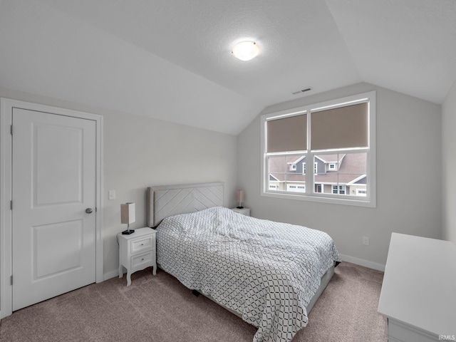 carpeted bedroom with lofted ceiling