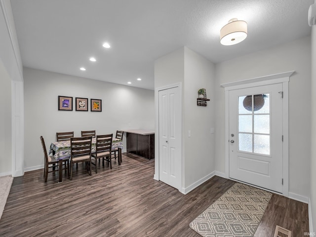 entrance foyer featuring dark hardwood / wood-style flooring and a textured ceiling