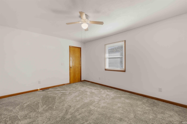 carpeted spare room featuring ceiling fan