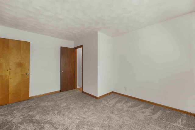 unfurnished room with carpet floors and a textured ceiling