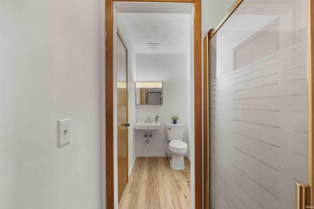 bathroom featuring wood-type flooring and toilet