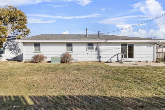 rear view of property featuring a patio and a lawn