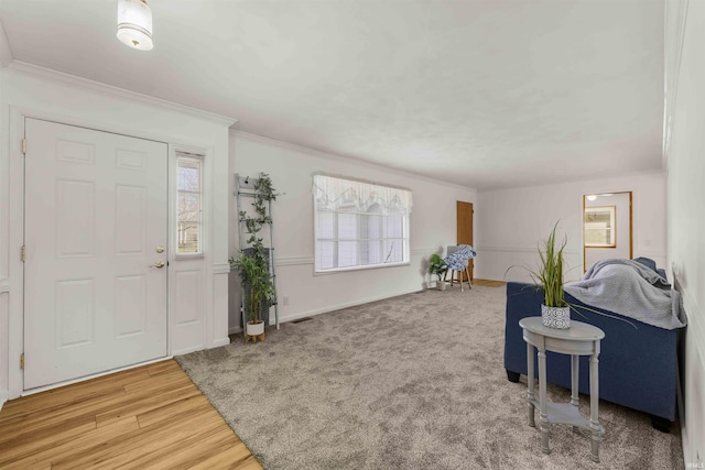 foyer entrance featuring crown molding, a healthy amount of sunlight, and hardwood / wood-style flooring