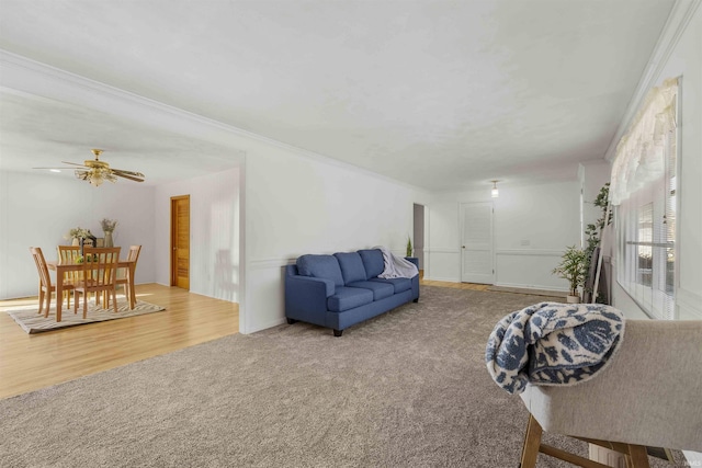 living room featuring ornamental molding, carpet floors, and ceiling fan