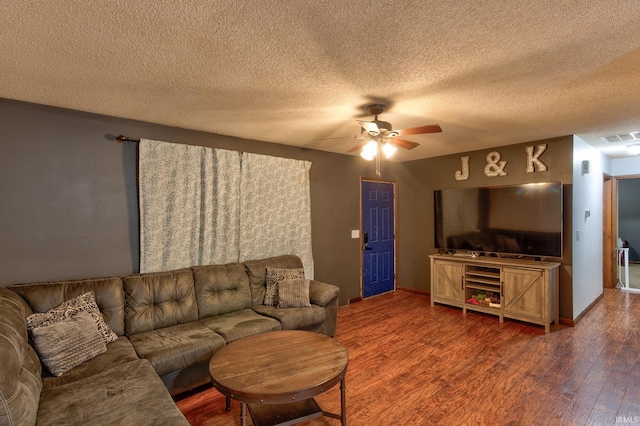 living room with ceiling fan, wood-type flooring, and a textured ceiling