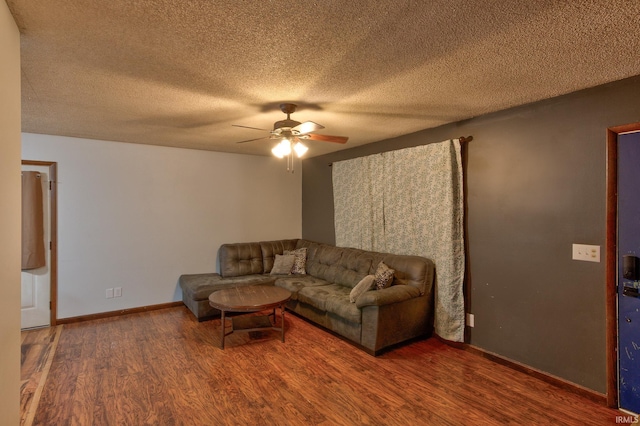 living room with wood-type flooring, a textured ceiling, and ceiling fan