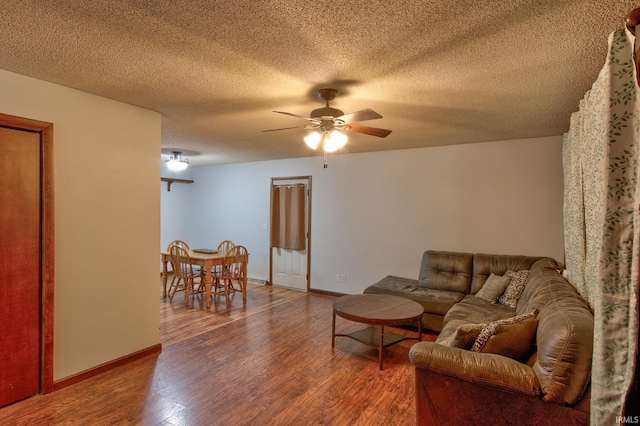 living room with wood-type flooring, a textured ceiling, and ceiling fan