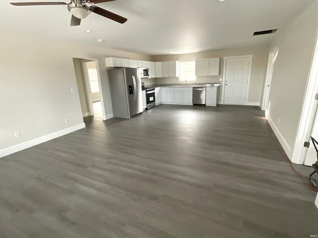 unfurnished living room with dark wood-type flooring and ceiling fan