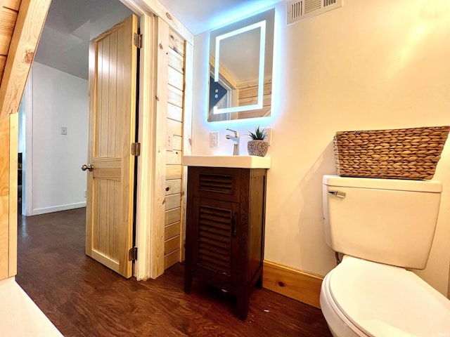 bathroom with vanity, wood-type flooring, and toilet