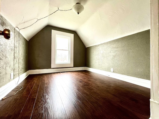 bonus room with wood-type flooring and vaulted ceiling