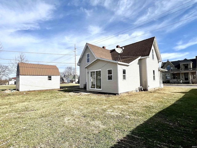 back of house featuring a storage unit and a lawn