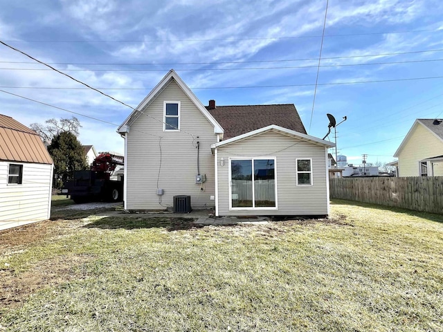 rear view of property with a yard and central air condition unit