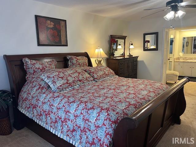 carpeted bedroom featuring ensuite bathroom and ceiling fan