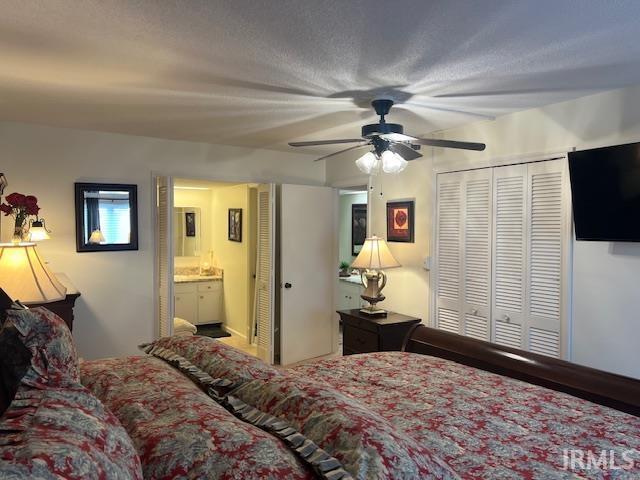 bedroom with a textured ceiling, ensuite bath, a closet, and ceiling fan