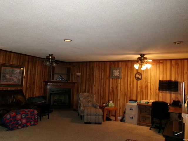 living room featuring carpet, ceiling fan, and wood walls