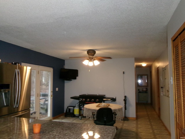 kitchen featuring ceiling fan, stainless steel fridge, and a textured ceiling