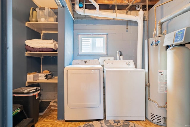 laundry area featuring washer and clothes dryer, gas water heater, and light parquet flooring