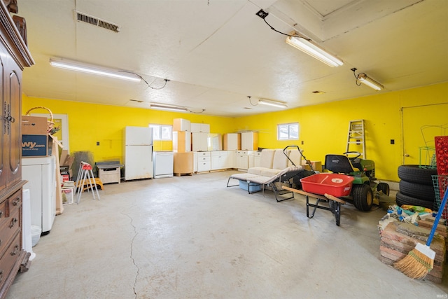 garage with washer / clothes dryer and white refrigerator