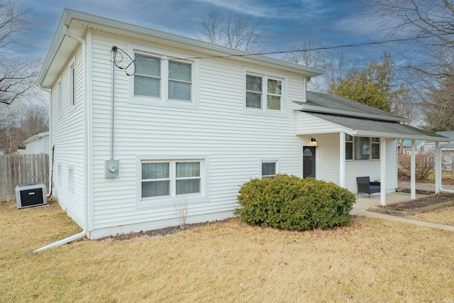 tri-level home featuring cooling unit, a patio, and a front lawn