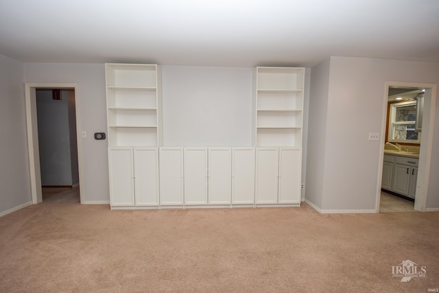 unfurnished bedroom featuring sink and light colored carpet