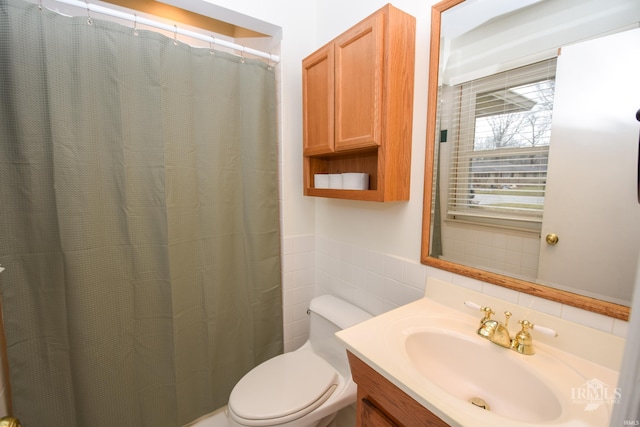 bathroom with walk in shower, vanity, toilet, and tile walls