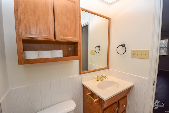 bathroom with vanity, tile walls, and toilet