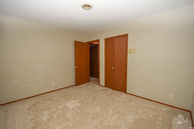 unfurnished bedroom featuring carpet flooring and a closet