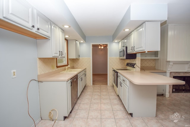 kitchen featuring sink, a breakfast bar area, white cabinetry, light tile patterned floors, and appliances with stainless steel finishes