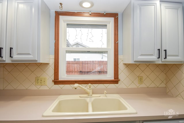 kitchen with sink, white cabinets, and decorative backsplash