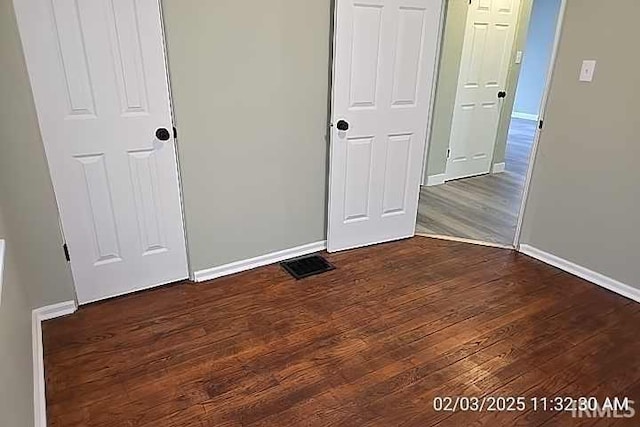 unfurnished bedroom featuring dark wood-type flooring