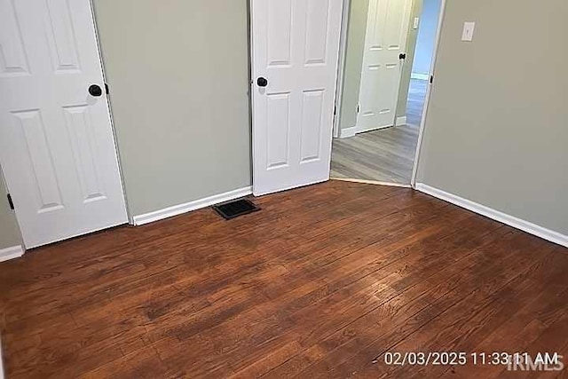 unfurnished bedroom with dark wood-type flooring