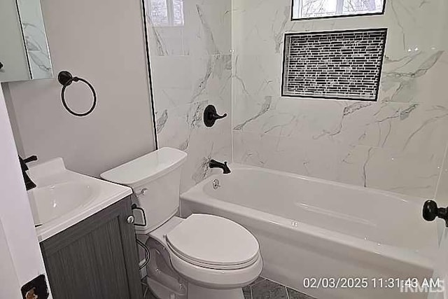 full bathroom with tiled shower / bath, vanity, and toilet