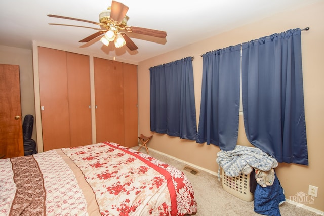 bedroom featuring ceiling fan, multiple closets, and carpet flooring