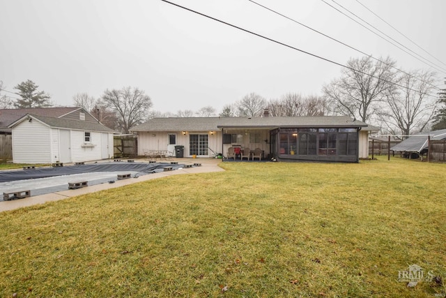 view of front facade with a front lawn, a storage unit, a patio area, and a sunroom