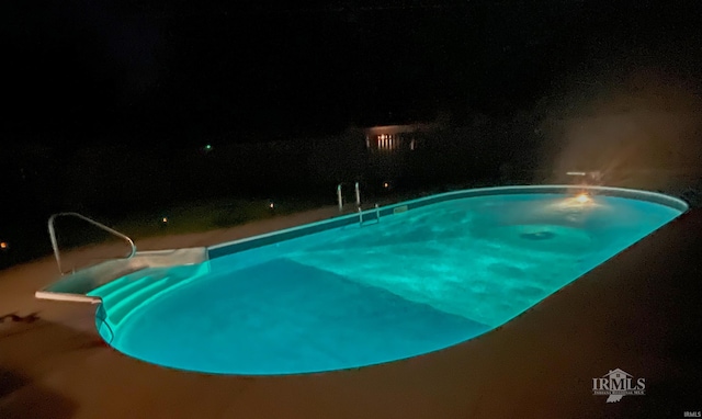 view of pool at twilight