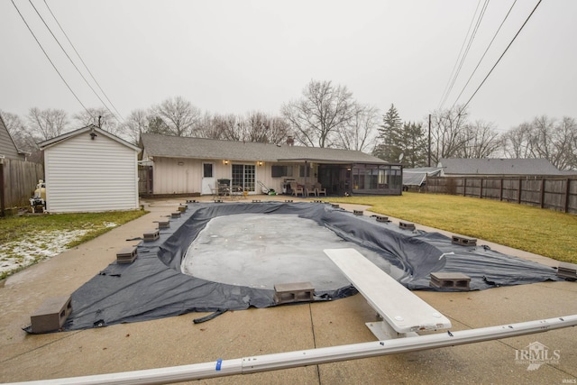 view of front of house featuring a storage unit, a covered pool, and a front yard