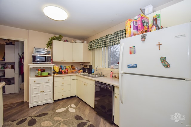 kitchen featuring dark hardwood / wood-style floors, dishwasher, sink, white fridge, and cream cabinetry