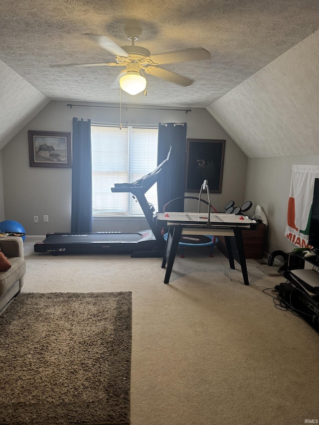 interior space with vaulted ceiling, ceiling fan, and a textured ceiling