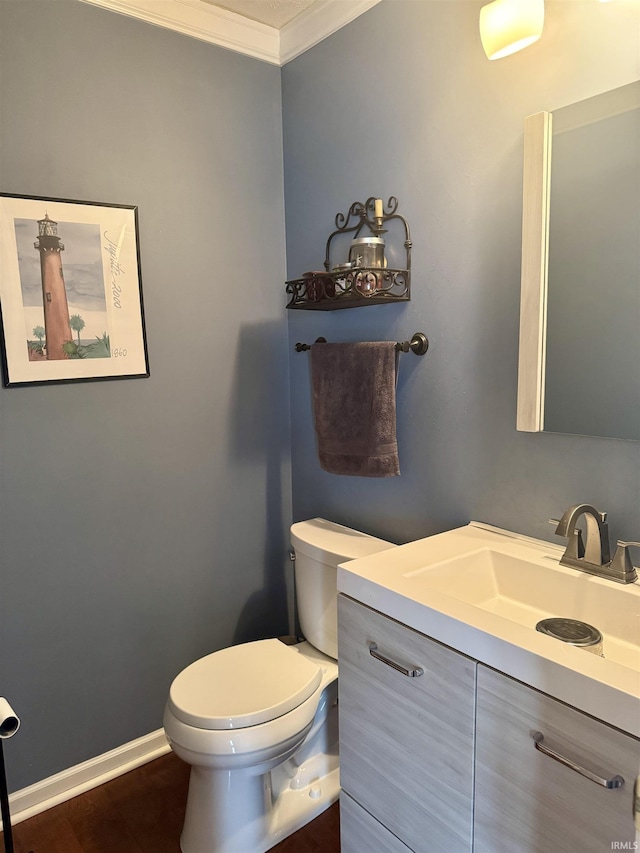 bathroom with vanity, hardwood / wood-style floors, crown molding, and toilet