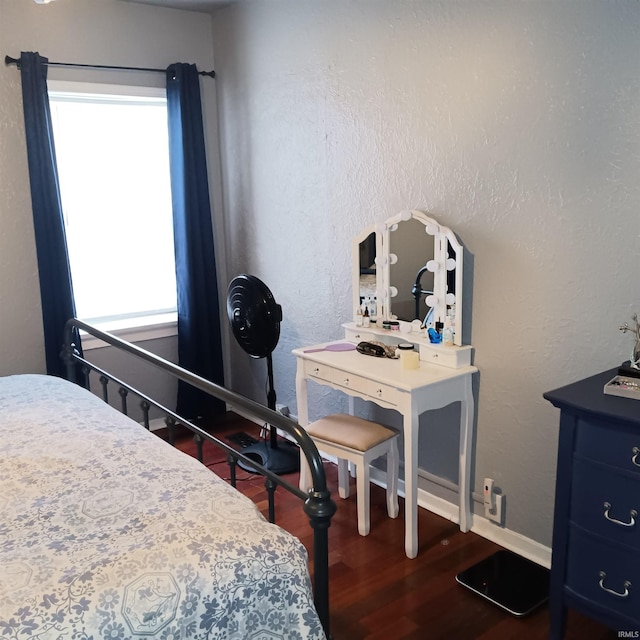 bedroom with dark hardwood / wood-style flooring and multiple windows