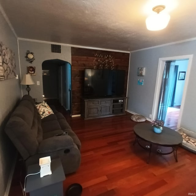 living room with dark wood-type flooring and ornamental molding