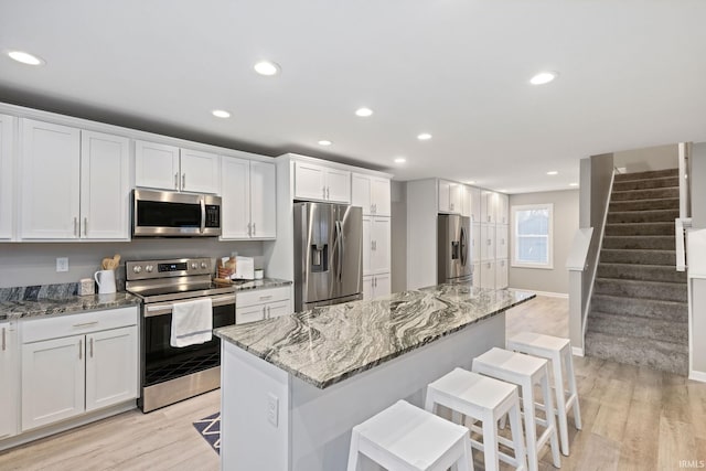 kitchen featuring white cabinetry, light stone counters, and stainless steel appliances