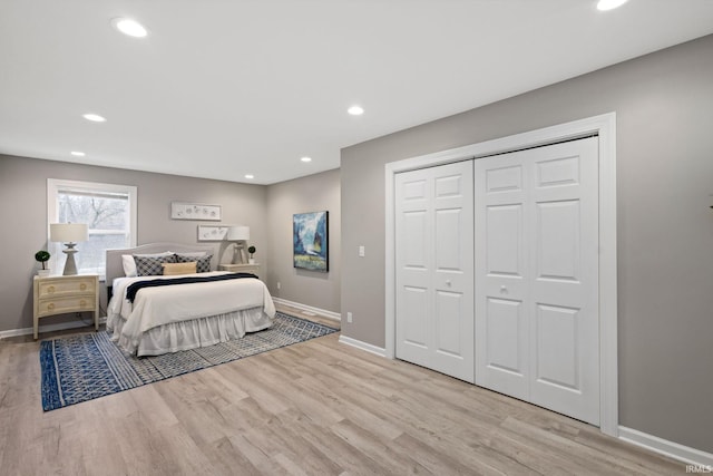 bedroom with light hardwood / wood-style floors and a closet