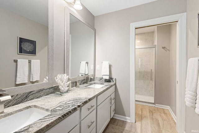 bathroom with a shower with door, vanity, and hardwood / wood-style floors