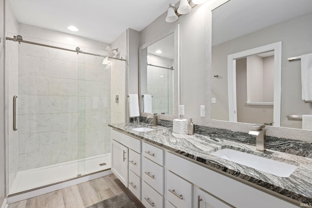 bathroom featuring wood-type flooring, an enclosed shower, and vanity