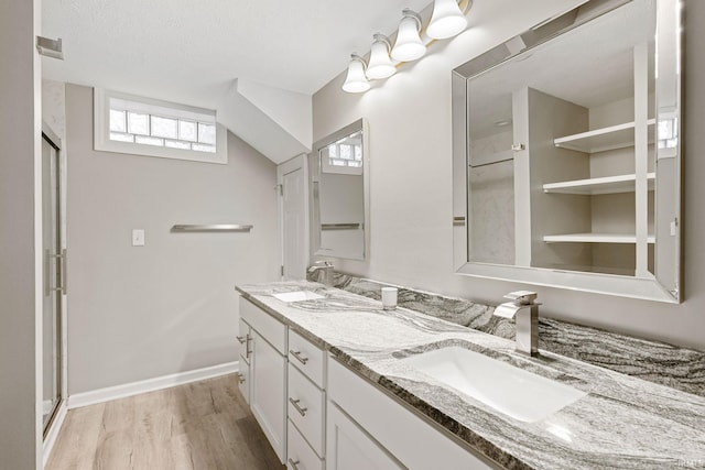 bathroom with hardwood / wood-style flooring, vanity, walk in shower, and a textured ceiling